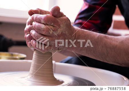 Potter wheel and hands of craftsman making a jug 76887558