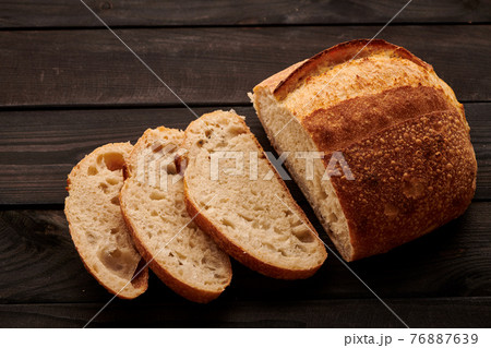 Homemade tartine bread on dark wooden table Homemade tartine bread on dark wooden table 76887639