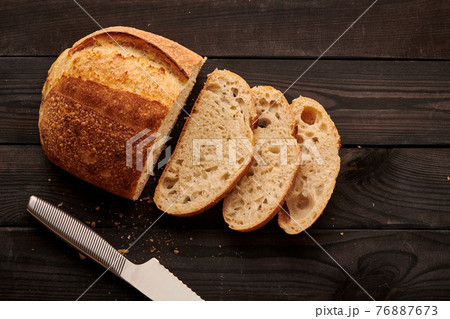 Homemade tartine bread on dark wooden table Homemade tartine bread on dark wooden table 76887673