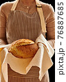 Baker holding loaf of homemade bread 76887685