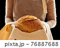 Baker holding loaf of homemade bread 76887688