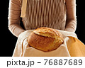 Baker holding loaf of homemade bread 76887689