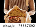 Baker holding loaf of homemade bread 76887692
