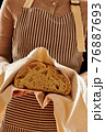 Baker holding loaf of homemade bread 76887693