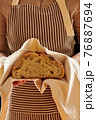 Baker holding loaf of homemade bread 76887694
