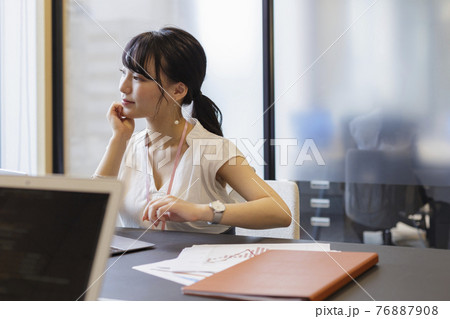オフィスのデスクで考え事をする女性 オフィスのデスクで考え事をする女性 76887908