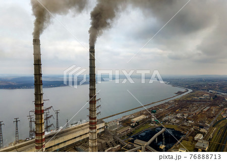 Aerial view of coal power plant high pipes with black smoke moving up polluting atmosphere. Aerial view of coal power plant high pipes with black smoke moving up polluting atmosphere. 76888713