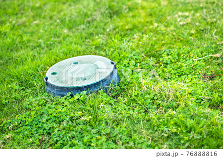 Closeup of green plastic pipe with cover on green grass lawn. Closeup of green plastic pipe with cover on green grass lawn. 76888816