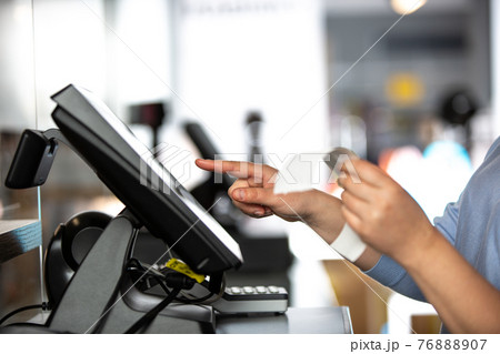 Young woman doing process payment with the bill or invoice on the POS cash terminal in the shop, finance concept Young woman doing process payment with the bill or invoice on the POS cash terminal in the shop, finance concept 76888907