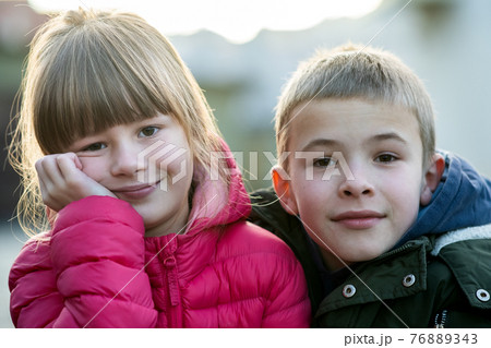 Two children boy and girl fooling around having fun together outdoors on sunny fall day. Happy childhood concept. 76889343