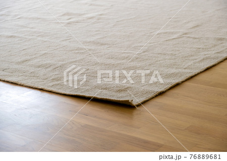 Close up of crumpled carpet laying on parquet wooden floor. Close up of crumpled carpet laying on parquet wooden floor. 76889681