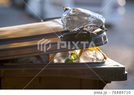 Closeup of trash can container full of garbage. Closeup of trash can container full of garbage. 76889710