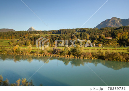 Aerial view of green meadows with villages and forest in austrian Alps mountains. 76889781