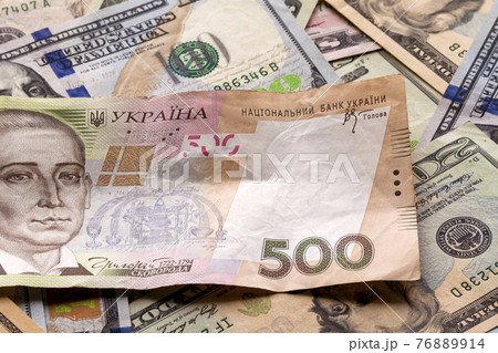 Money and finances concept. Ukrainian national currency bill worth five hundred grivna on colorful abstract background of American dollar different banknotes. Money and finances concept. Ukrainian national currency bill worth five hundred grivna on colorful abstract background of American dollar different banknotes. 76889914