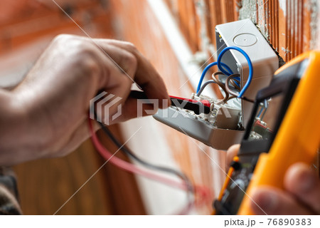 Electrician at work on a residential electrical system. Electricity. 76890383