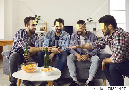 Happy friends having a party, drinking beer, playing games and enjoying good time together 76891467