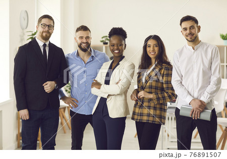 Portrait of confident young black businesswoman with team of her happy employees Portrait of confident young black businesswoman with team of her happy employees 76891507