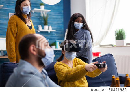 Mixed raced friends in living room having video game competion Mixed raced friends in living room having video game competion 76891985