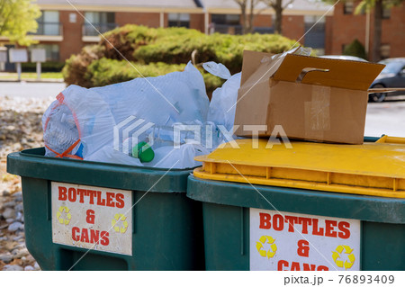 Garbage containers near apartment building in district garbage bins to help separate recycle Garbage containers near apartment building in district garbage bins to help separate recycle 76893409