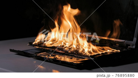 Burning laptop computer electronics closeup 76895880