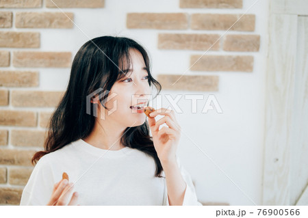 クッキーを食べる若い女性 76900566