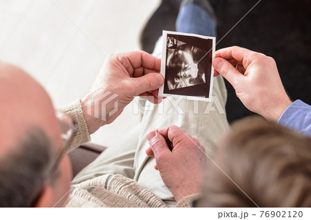 The future father holds the ultrasound picture 76902120