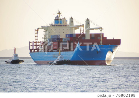初航海から西日をあびて大阪港に入港する新造コンテナ船 76902199