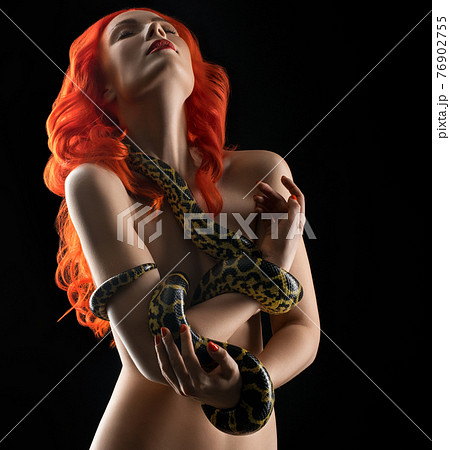 Nude redhead woman with snake in studio 76902755