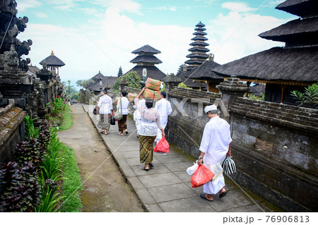Balinese people walk in traditional dress in Pura Besakih 76906813