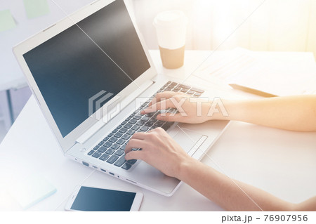 Close up of old woman's hands on keyboard of lap top, people working at home, using pc and smartphone concept, modern white notebook with blank screen on table. Internrt, work, technology concept. 76907956