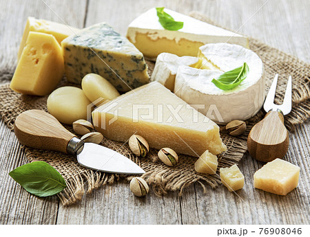 Different types of cheese with basil and nuts 76908046
