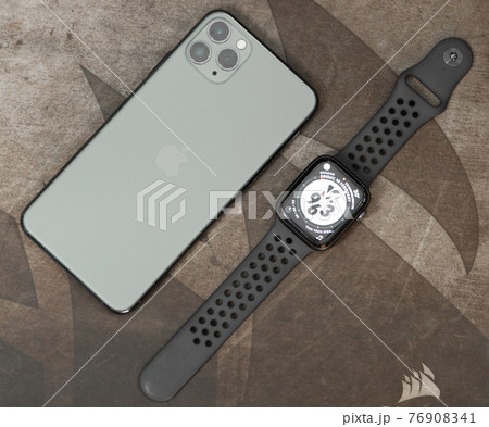 Galle, Sri Lanka - 02 19 2021: Apple iPhone 11 pro max and apple watch series 6 lay flat parallel to each on a wooden table, luxury, and lifestyle concept. overhead view photograph. Galle, Sri Lanka - 02 19 2021: Apple iPhone 11 pro max and apple watch series 6 lay flat parallel to each on a wooden table, luxury, and lifestyle concept. overhead view photograph. 76908341