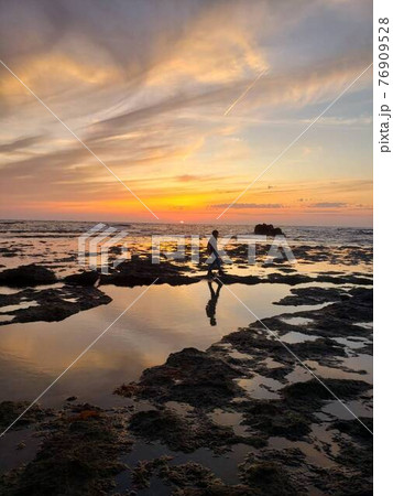 日本のウユニ塩湖（新潟県佐渡島・万畳敷の夕焼けと人） 76909528