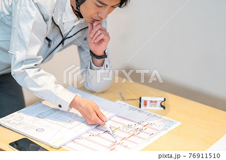 工事工程表を確認する現場監督 工事工程表を確認する現場監督 76911510