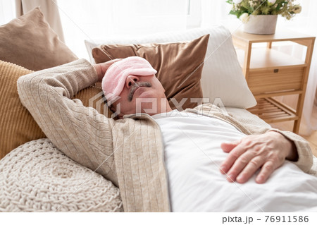 Sleeping senior man in sleep eye mask on bed. Sleeping senior man in sleep eye mask on bed. 76911586