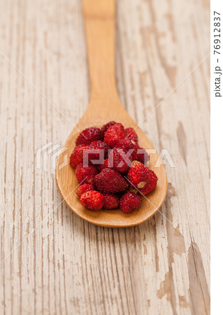 Fresh strawberries in wooden spoon on white vintage background. Healthy eating Fresh strawberries in wooden spoon on white vintage background. Healthy eating 76912837