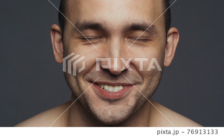 Photo of laughing brunette adult man on grey Photo of laughing brunette adult man on grey 76913133