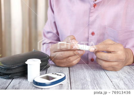 man's hand measuring blood sugar level  76913436