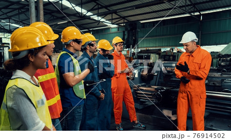 Skillful worker attending brief meeting in the factory . 76914502