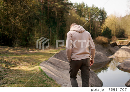 A man walks through the woods next to a rowing canal or mountain river A man walks through the woods next to a rowing canal or mountain river 76914707