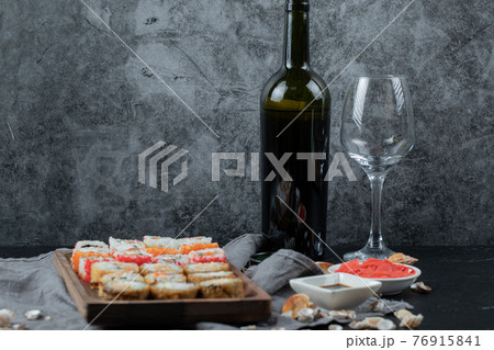 Sushi set with a bottle and glass of white wine 76915841