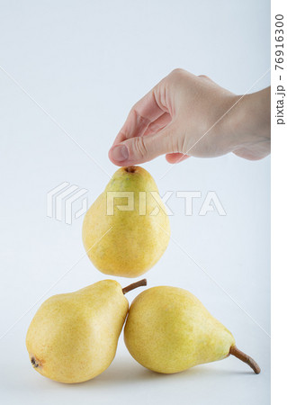Woman hands holding pear on white background Woman hands holding pear on white background 76916300