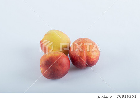 Three fresh nectarines on a white background 76916301