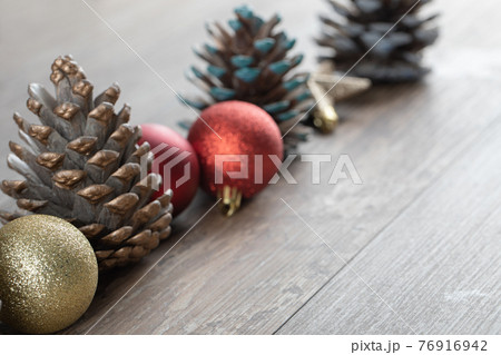 Natural oak tree cones on a wooden deck with glittering ornaments around Natural oak tree cones on a wooden deck with glittering ornaments around 76916942
