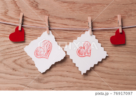 two blank sheets and red hearts with clothespins on a rope two blank sheets and red hearts with clothespins on a rope 76917097