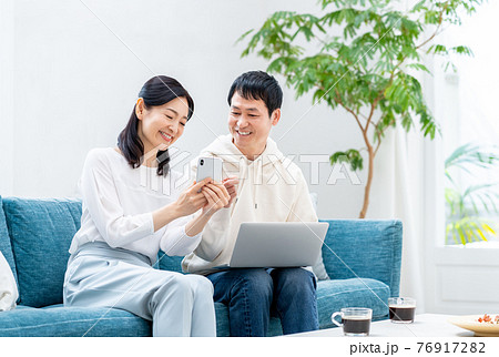 リビングでくつろぐミドルの夫婦 76917282