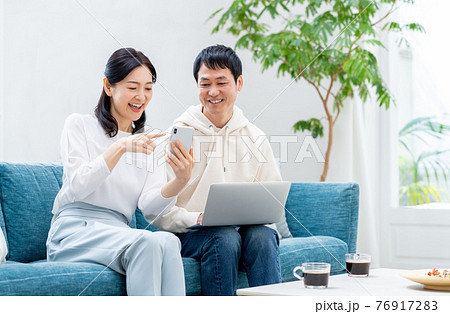 リビングでくつろぐミドルの夫婦 リビングでくつろぐミドルの夫婦 76917283