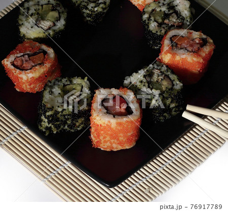 Sushi Set - different types of Maki sushi and chopsticks on a b Sushi Set - different types of Maki sushi and chopsticks on a b 76917789