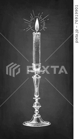 Thin candle burning in a candlestick. Thin candle burning in a candlestick. 76919901