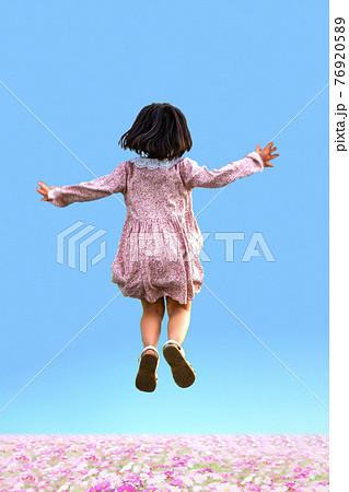 青空と花畑を背景にジャンプする幼い女の子の後ろ姿の写真素材 7695